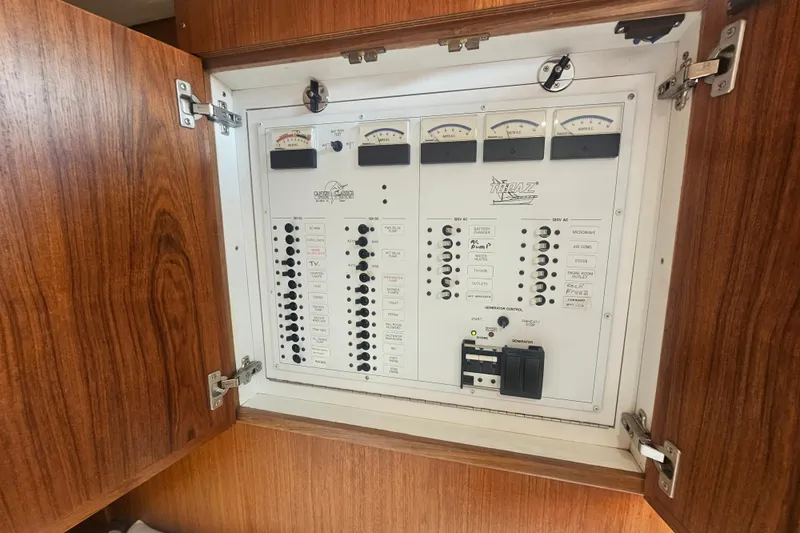 Slide: The Image of Electrical panel of a 2003 Topaz 32 Express boat with wooden cabinet doors. - 49