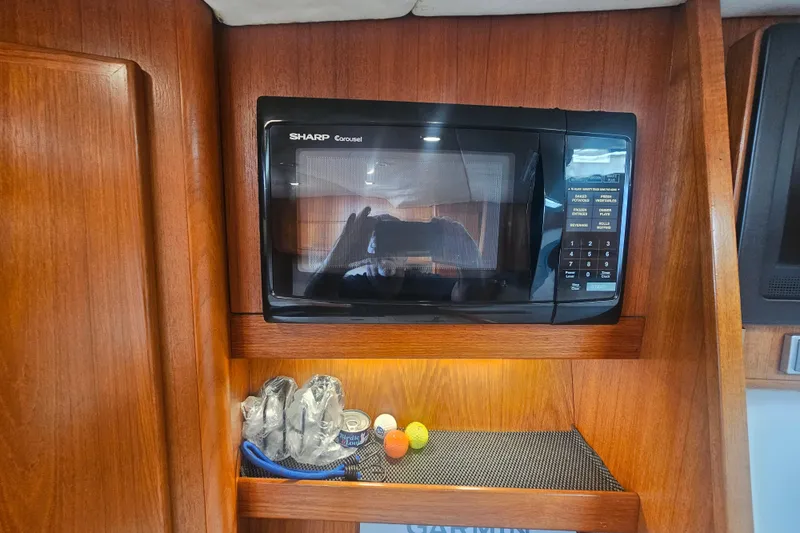 Slide: The Image of Sharp Carousel microwave in 2003 Topaz 32 Express boat interior with wooden cabinetry. - 53