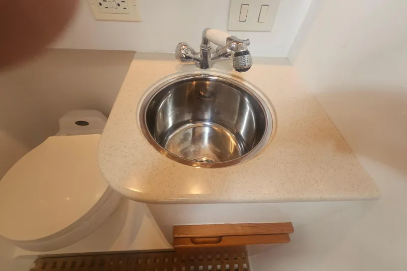Slide: The Image of Compact bathroom sink and toilet on a 2003 Topaz 32 Express boat. - 57