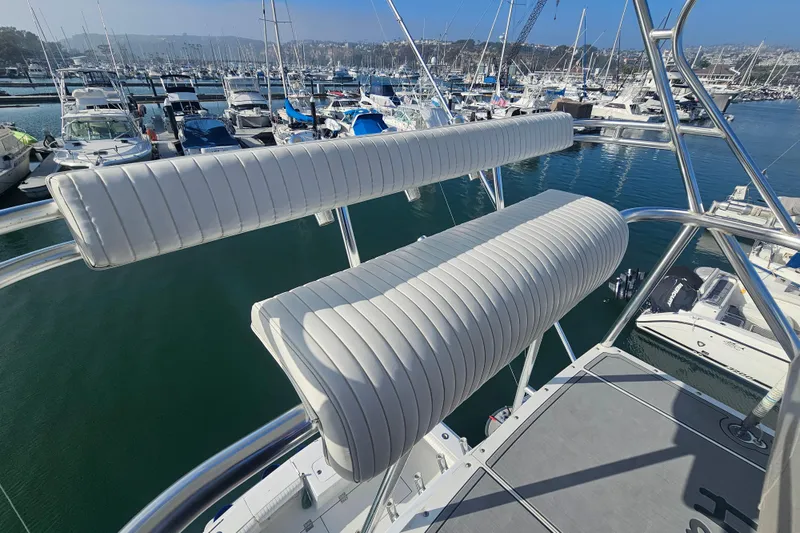 Slide: The Image of 2003 Topaz 32 Express boat with white cushioned seating at a marina. - 7