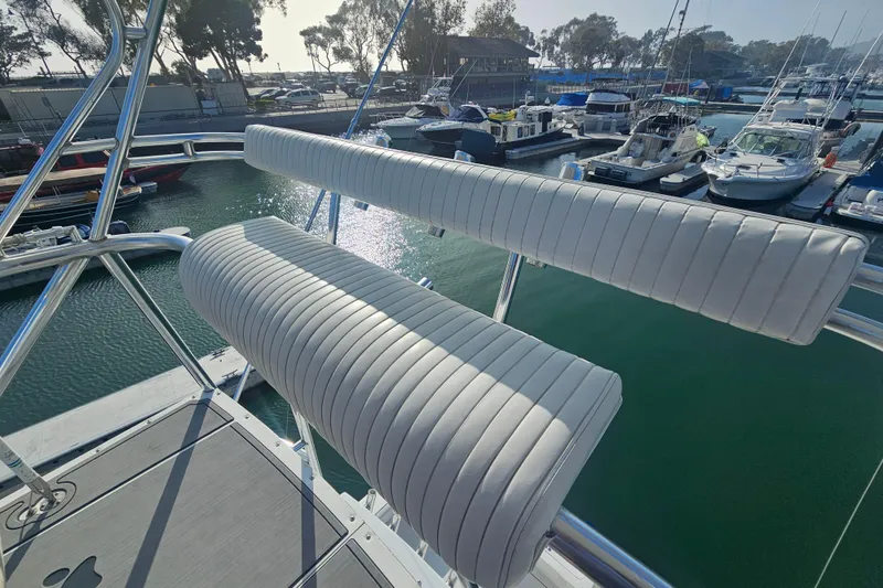 Slide: The Image of 2003 Topaz 32 Express boat with white cushioned seating at a marina. - 8