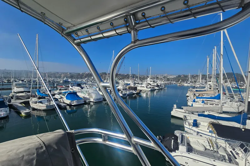 Slide: The Image of Marina view from a 2003 Topaz 32 Express boat, showcasing docked yachts and clear blue skies. - 9
