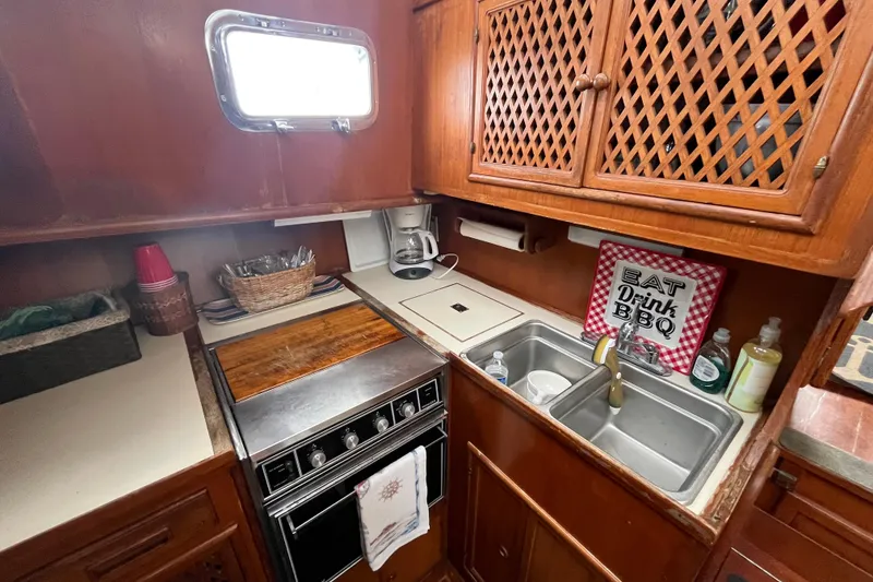 Slide: The Image of 1984 Tung Hwa Princess Aft Cabin kitchen with stove, sink, and wooden cabinets. - 25