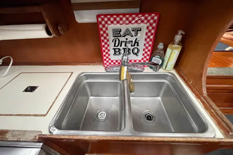 Slide: The Image of 1984 Tung Hwa Princess Aft Cabin kitchen sink with BBQ-themed decor and soap bottles. - 28