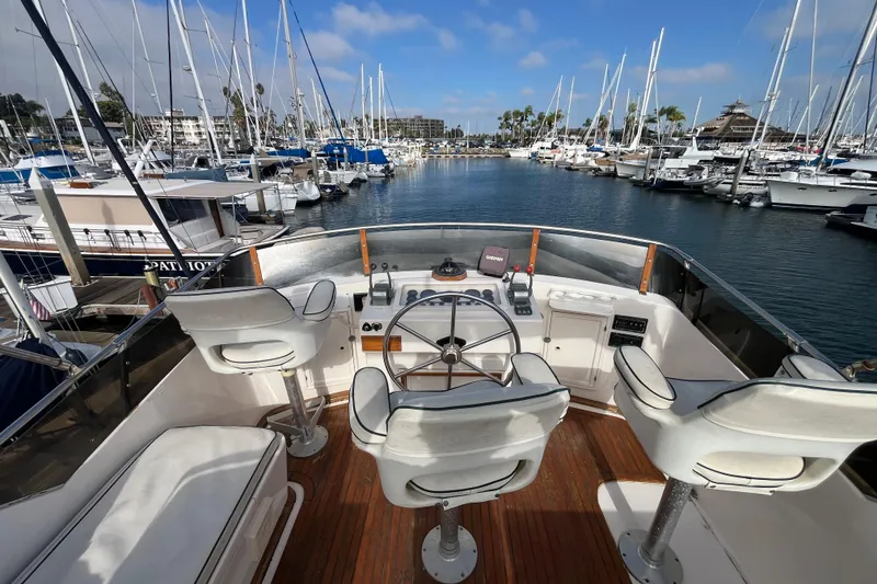 Slide: The Image of 1984 Tung Hwa Princess Aft Cabin yacht helm with marina view, featuring white seating and controls. - 9