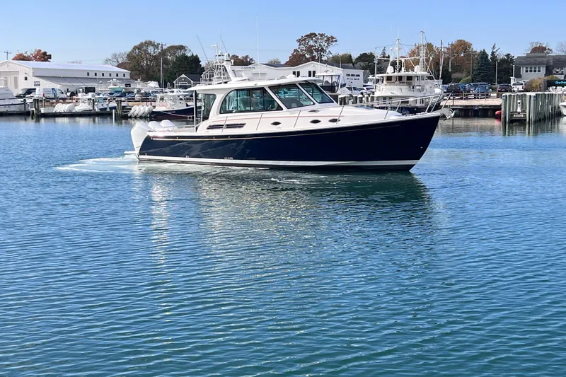 The Image of 2024 Back Cove 39O boat cruising in a marina with clear blue water. - 0