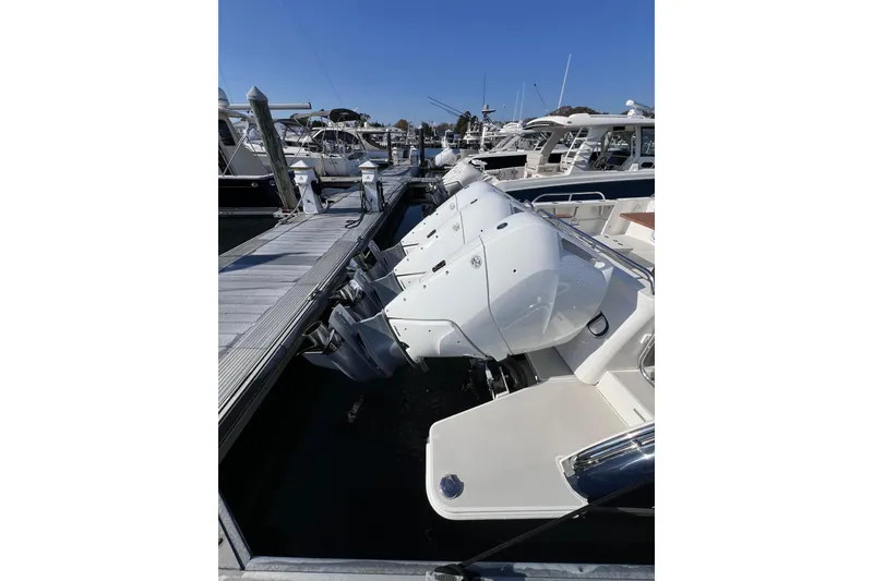 Slide: The Image of 2024 Back Cove 39O boat with triple outboard engines docked at marina. - 15