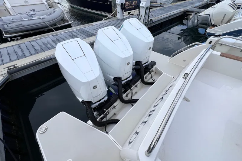 Slide: The Image of 2024 Back Cove 39O boat with triple outboard engines docked at marina. - 25