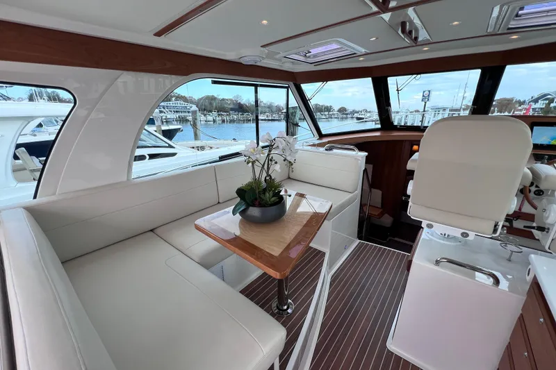 Slide: The Image of Luxurious interior of 2024 Back Cove 39O yacht with elegant seating and scenic marina view. - 29