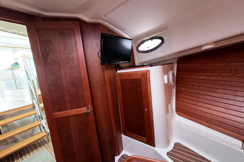 Slide: The Image of 2024 Back Cove 39O interior with wood paneling, TV, and stairs. - 35