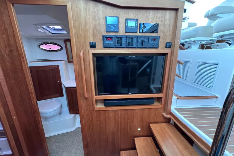 Slide: The Image of 2024 Back Cove 39O yacht interior with TV, control panel, and bathroom. - 39