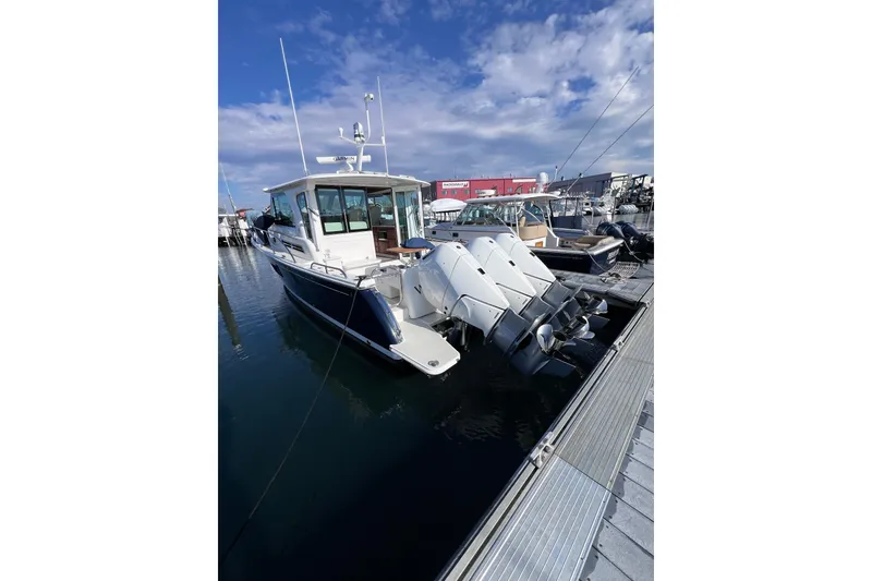 Slide: The Image of 2024 Back Cove 39O boat docked with triple outboard engines under a blue sky. - 7