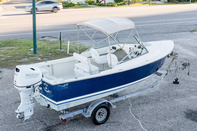 Slide: The Image of 2004 Hoby Pilot 19 boat on trailer with Suzuki outboard motor, parked roadside. - 1