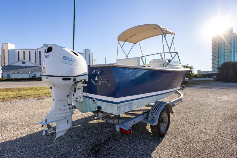 Slide: The Image of 2004 Hoby Pilot 19 boat with Suzuki engine on trailer, sunny day backdrop. - 11
