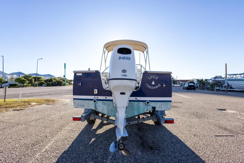 Slide: The Image of 2004 Hoby Pilot 19 boat on trailer, parked in sunny lot. - 12
