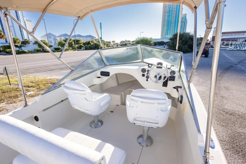 Slide: The Image of 2004 Hoby Pilot 19 boat interior with white seating and steering console. - 15