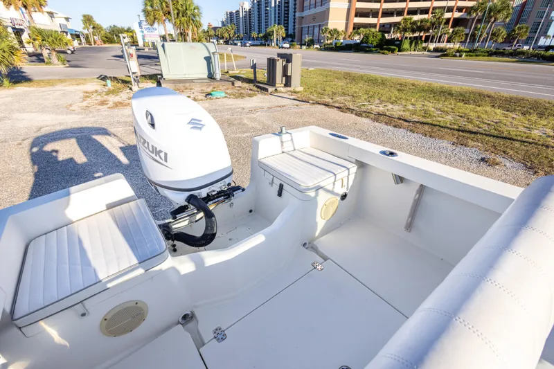 Slide: The Image of 2004 Hoby Pilot 19 boat with Suzuki outboard motor, parked near a road. - 17
