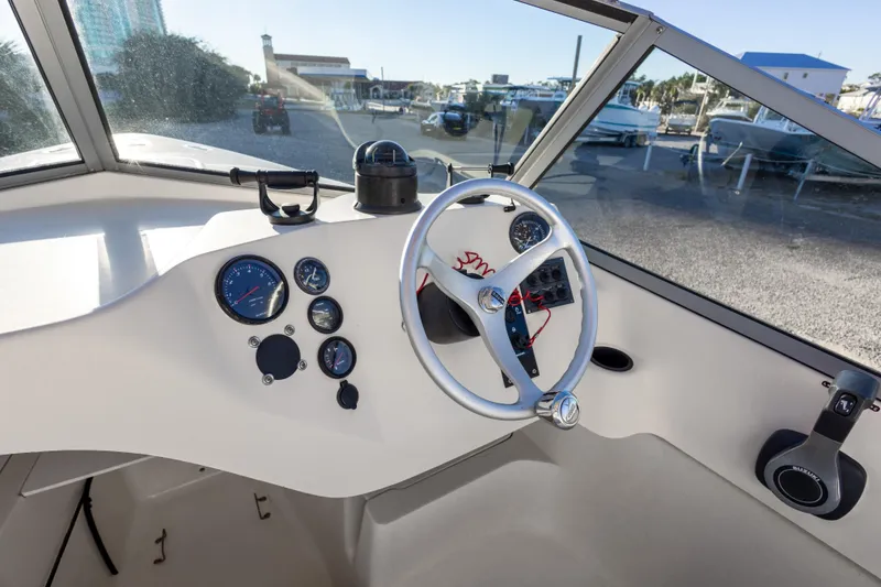 Slide: The Image of 2004 Hoby Pilot 19 boat cockpit with steering wheel and instrument panel. - 19