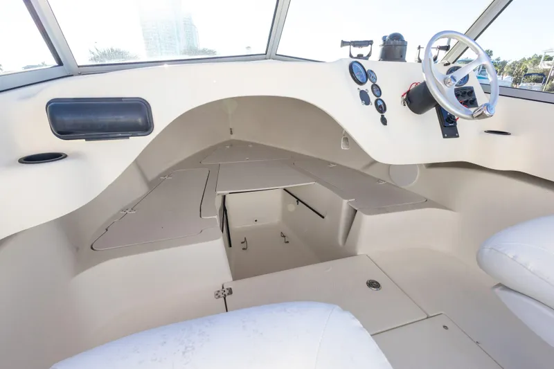 Slide: The Image of Interior of a 2004 Hoby Pilot 19 boat, featuring a sleek dashboard and seating area. - 20