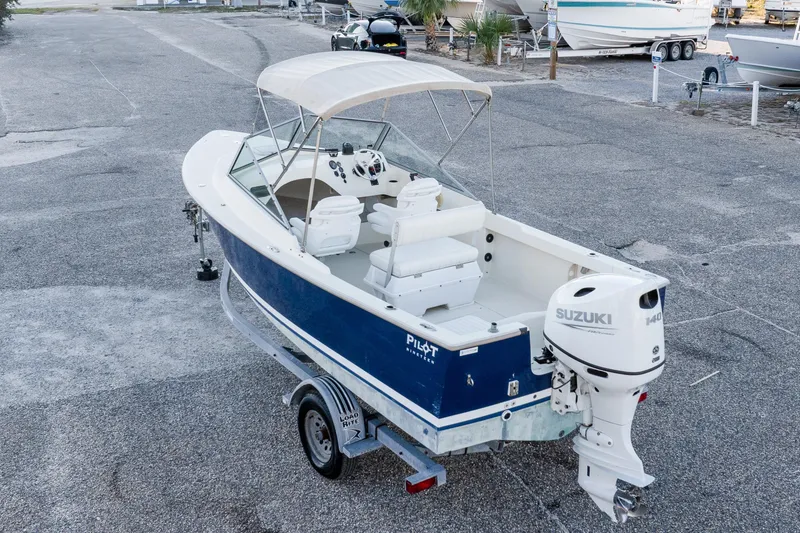 Slide: The Image of 2004 Hoby Pilot 19 boat with Suzuki engine on trailer in parking lot. - 8