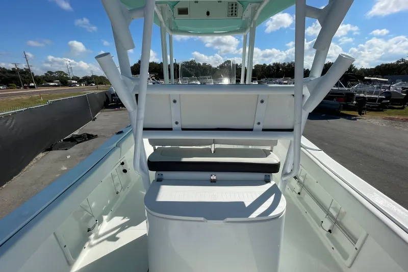 Slide: The Image of 2021 Clearwater 2200 boat interior with seating and storage, under a clear blue sky. - 12
