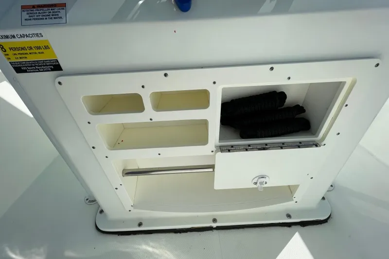 Slide: The Image of Storage compartment on a 2021 Clearwater 2200 boat with capacity label. - 18