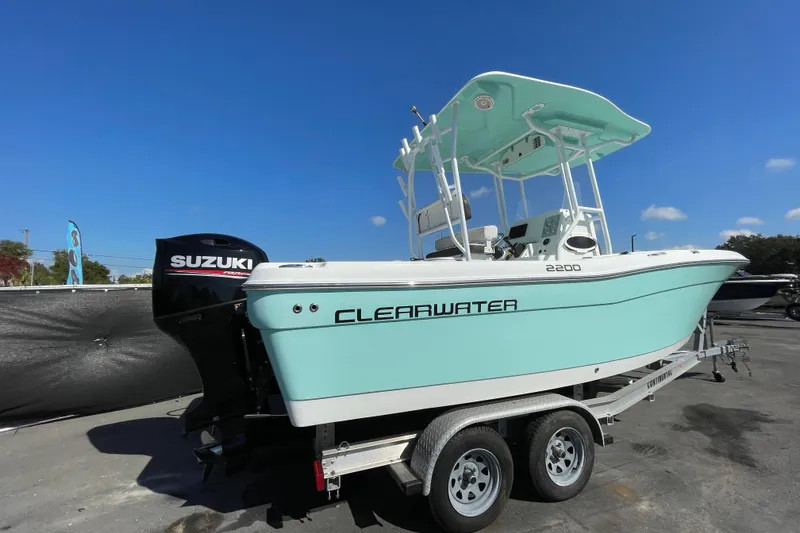 Slide: The Image of 2021 Clearwater 2200 boat with Suzuki engine on trailer under clear blue sky. - 2