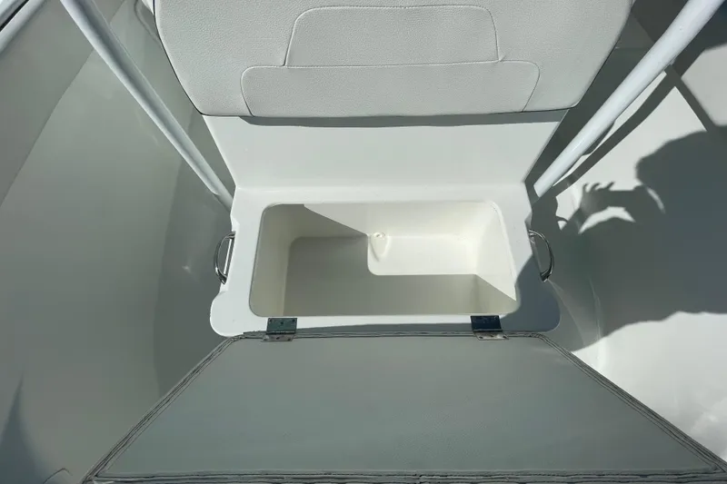 Slide: The Image of Open storage compartment on a 2021 Clearwater 2200 boat, featuring a cushioned seat. - 28