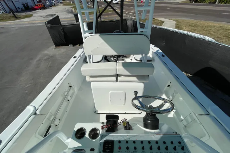 Slide: The Image of 2021 Clearwater 2200 boat interior with steering wheel and seating, docked outdoors. - 29