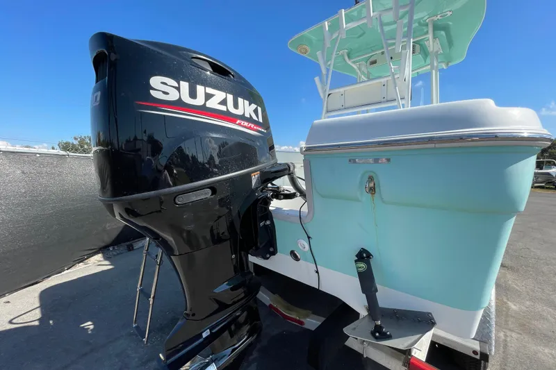 Slide: The Image of 2021 Clearwater 2200 boat with Suzuki outboard motor, parked outdoors. - 3