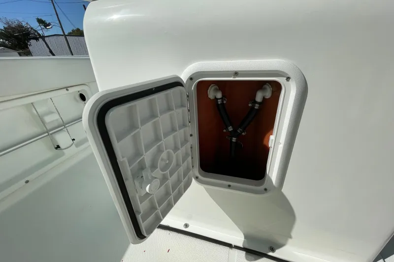 Slide: The Image of Open hatch on 2021 Clearwater 2200 boat showing internal plumbing components. - 35