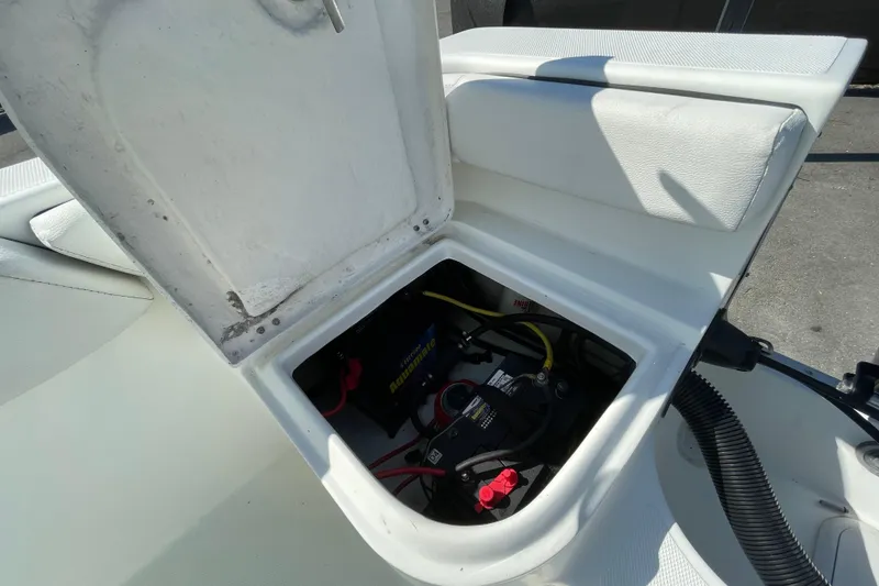 Slide: The Image of Open storage compartment in 2021 Clearwater 2200 boat, revealing battery and wiring. - 36