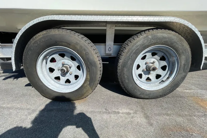 Slide: The Image of Trailer wheels of a 2021 Clearwater 2200 boat on asphalt surface. - 38