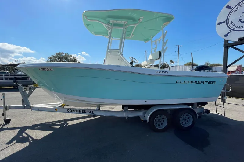 Slide: The Image of 2021 Clearwater 2200 boat on trailer, light blue hull, sunny day. - 7
