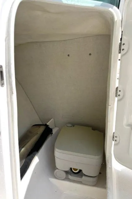 Slide: The Image of 2017 Robalo R207 Dual Console boat interior with compact portable toilet. - 10