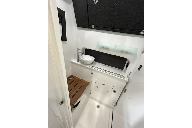 Slide: The Image of 2026 Blackfin 400 CC boat interior bathroom with modern sink and wooden accents. - 17