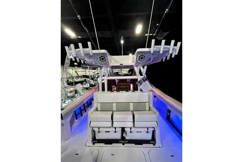 Slide: The Image of 2026 Blackfin 400 CC boat interior with seating and rod holders, showcased indoors. - 18
