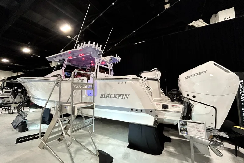 Slide: The Image of 2026 Blackfin 400 CC boat with Mercury engines displayed indoors. - 2