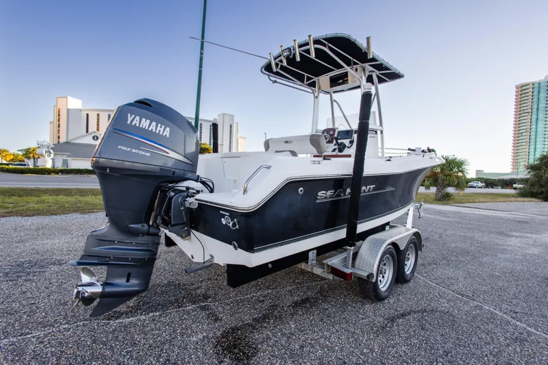 Slide: The Image of 2010 Sea Hunt Ultra 210 boat with Yamaha engine on trailer, parked outdoors. - 11