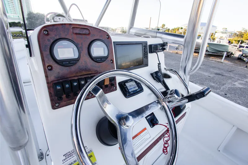 Slide: The Image of 2010 Sea Hunt Ultra 210 boat dashboard with steering wheel and navigation instruments. - 17