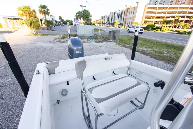 Slide: The Image of 2010 Sea Hunt Ultra 210 boat interior with Yamaha 150 engine, parked near a road. - 20