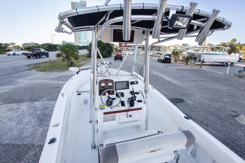 Slide: The Image of 2010 Sea Hunt Ultra 210 boat interior with console and seating, parked near marina. - 24