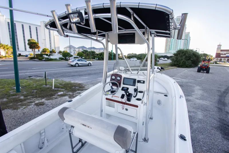 Slide: The Image of 2010 Sea Hunt Ultra 210 boat with console and seating, parked near a road. - 25