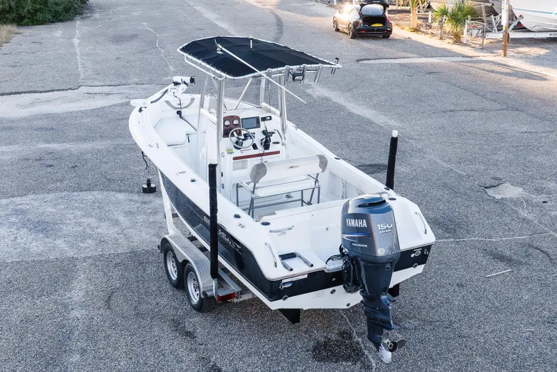 Slide: The Image of 2010 Sea Hunt Ultra 210 boat on trailer with Yamaha 150 engine, parked on asphalt. - 8