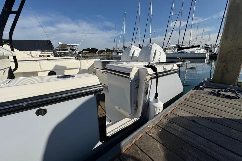 Slide: The Image of 2025 Robalo R270 Center Console docked at marina with clear blue sky. - 11