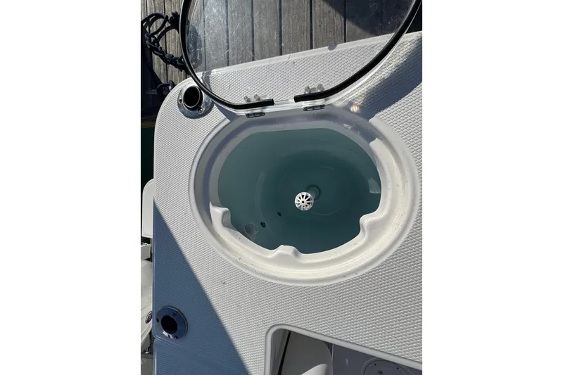Slide: The Image of 2025 Robalo R270 Center Console livewell with open lid on deck. - 14