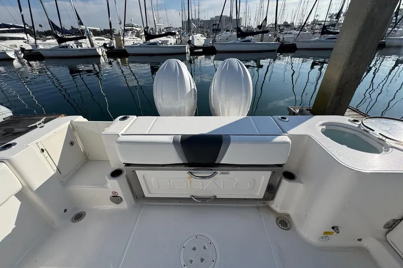 Slide: The Image of 2025 Robalo R270 Center Console boat interior with dual engines at marina. - 17