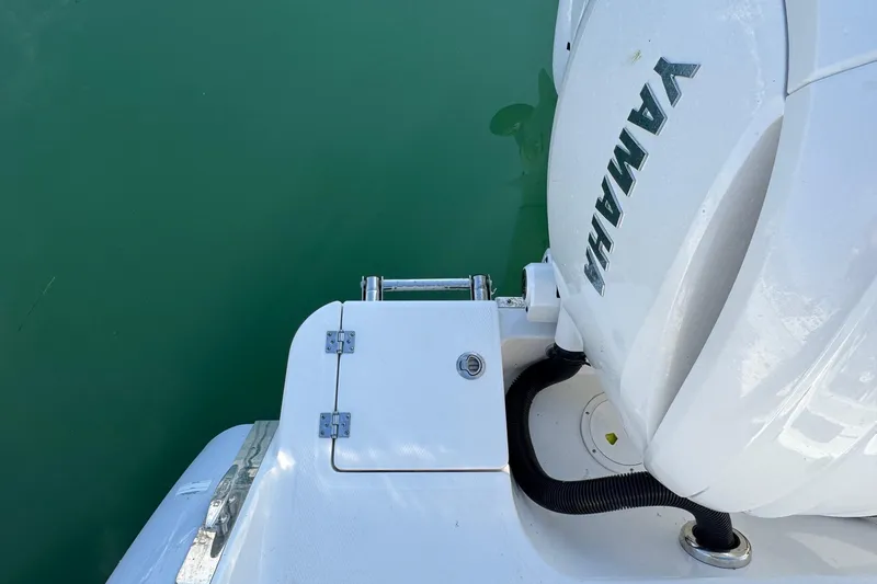 Slide: The Image of 2025 Robalo R270 Center Console boat with Yamaha engine, docked on calm water. - 20