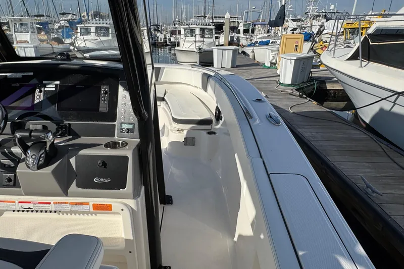 Slide: The Image of 2025 Robalo R270 Center Console boat docked at marina, featuring modern helm controls. - 31