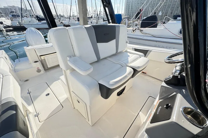 Slide: The Image of 2025 Robalo R270 Center Console boat interior with white seating at marina. - 42